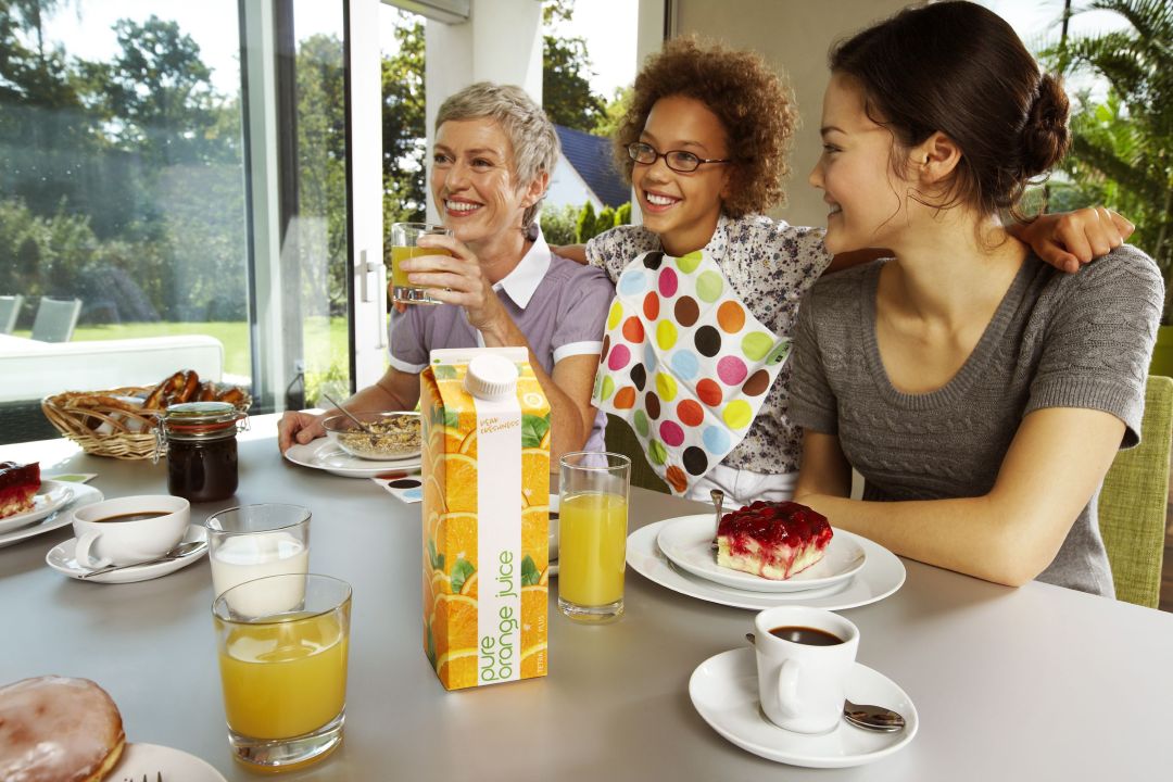 Familie am Frühstückstisch mit Getränkeverpackungen aus Verbundmaterialien