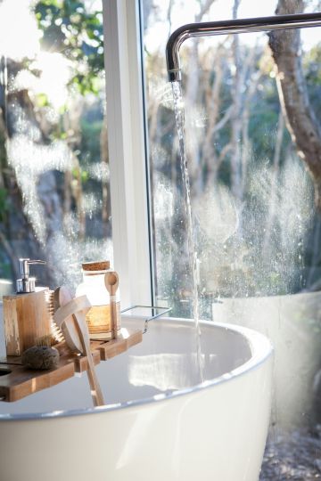 Wasser fließt aus dem Wasserhahn ins Waschbecken