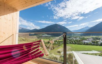 Hängematte auf Hotelbalkon mit Blick auf die Berge