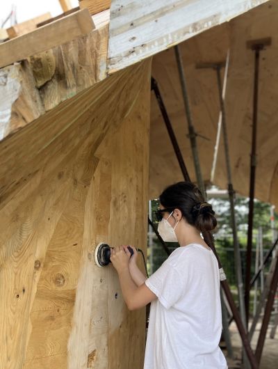 Studentin schleift Holzwand ab