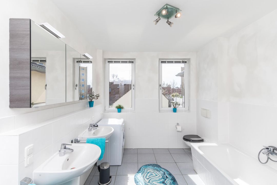 Kalkputz im Bad verarbeiten: zu sehen ist ein modernes, lichtdurchflutetes Badezimmer, komplett in weiß mit Kalkputz gestrichen.