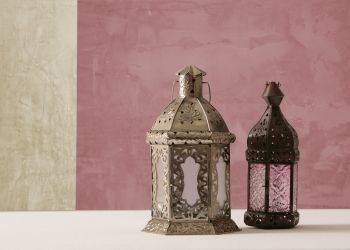 Lehm- und Kalkputz beim Hausbau: Vorteile und Tipps: zu sehen ist eine zweifarbige Wand mit Kalkputz in beige und altrosa. Im Vordergrund stehen zwei orientalische Laternen zur Deko