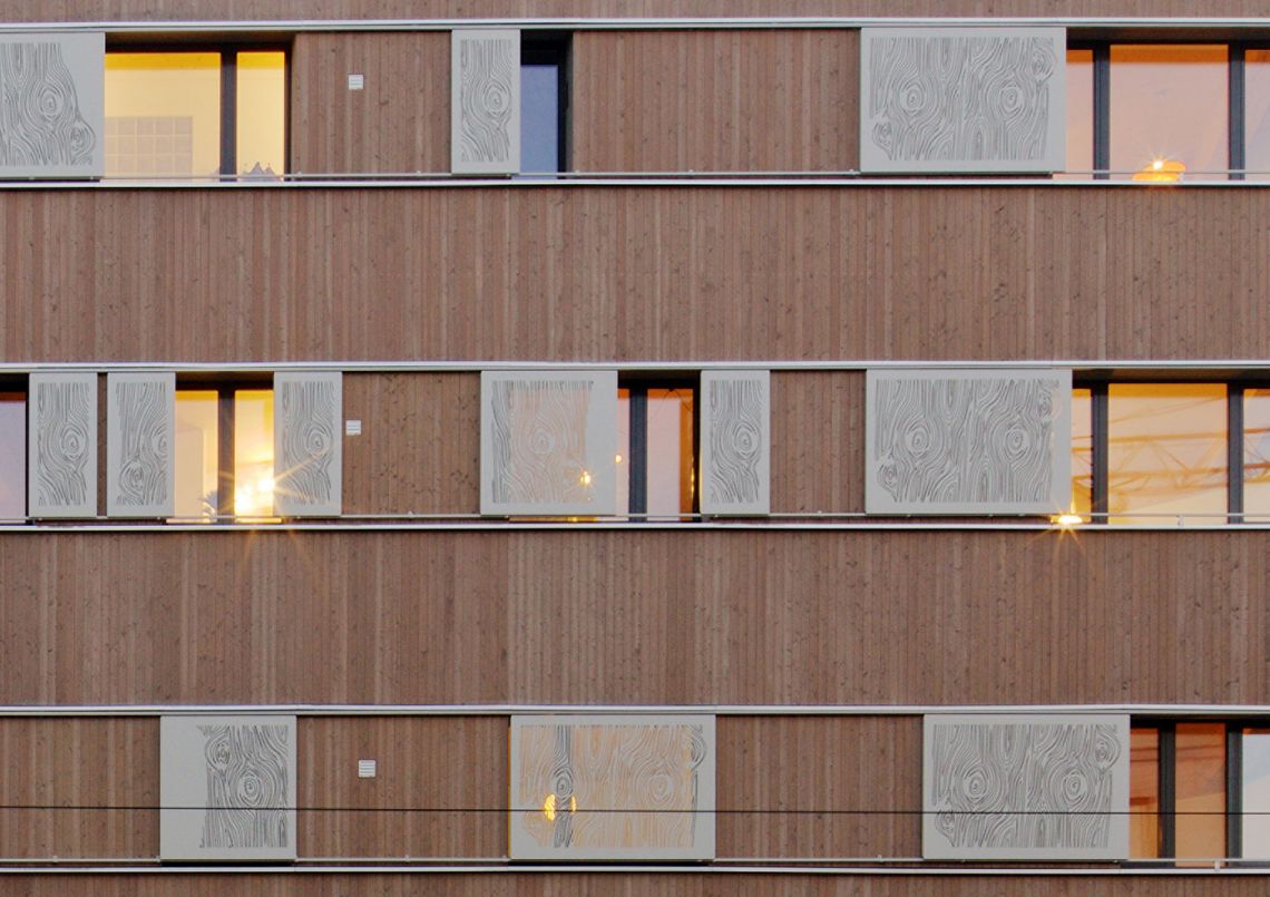 Massive Holzbauweise kombiniert mit gelasertem Aluminium: Fenster mit Aluminiumschiebeläden