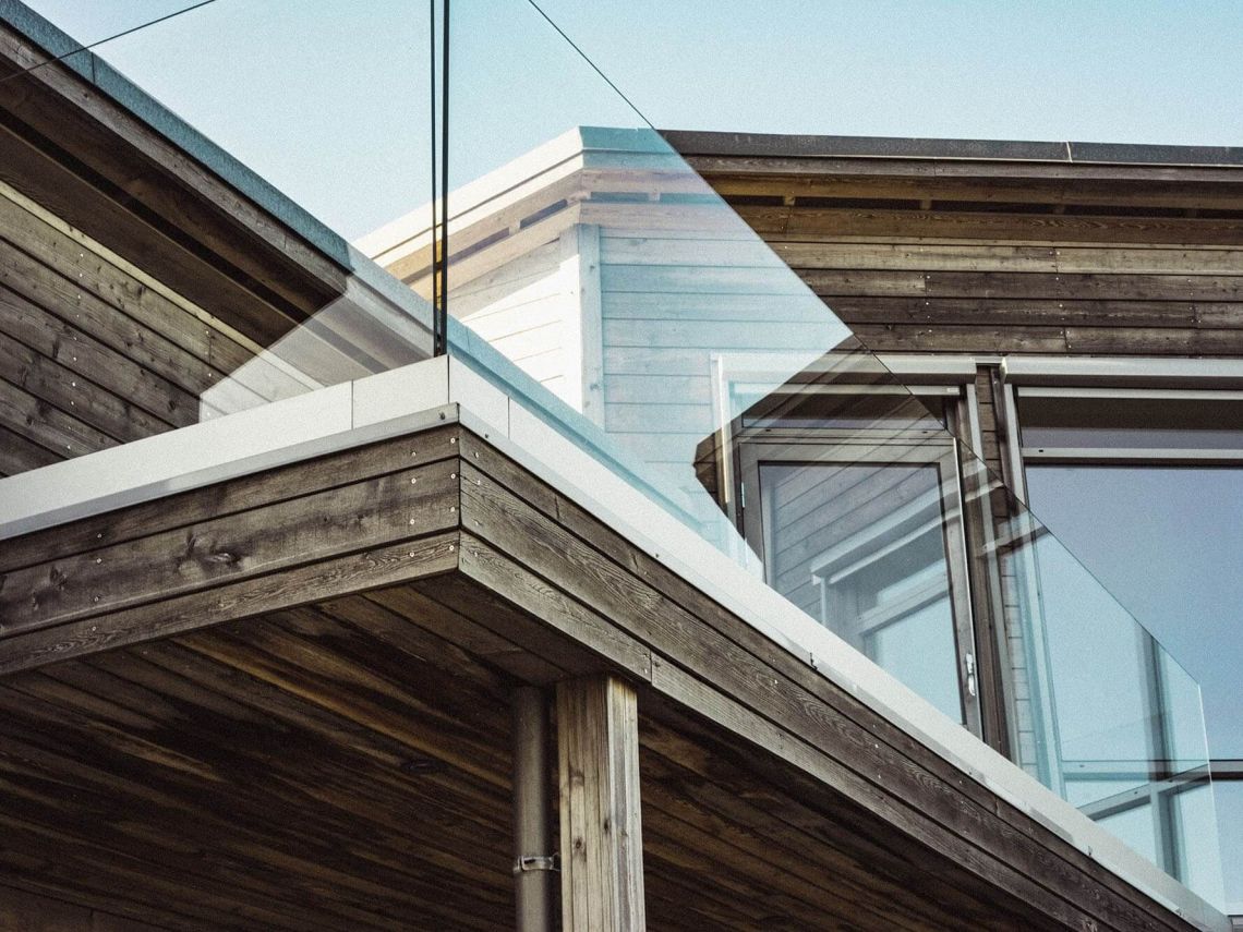 Angebauter Holzbalkon mit Geländer aus Glas